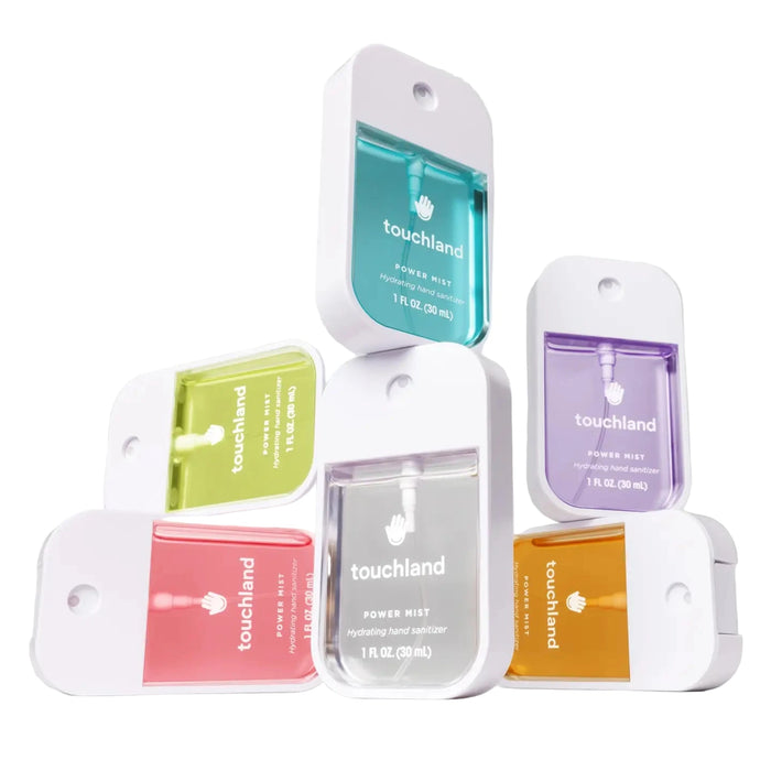 Collection of Touchland power mist packaging on a gray background